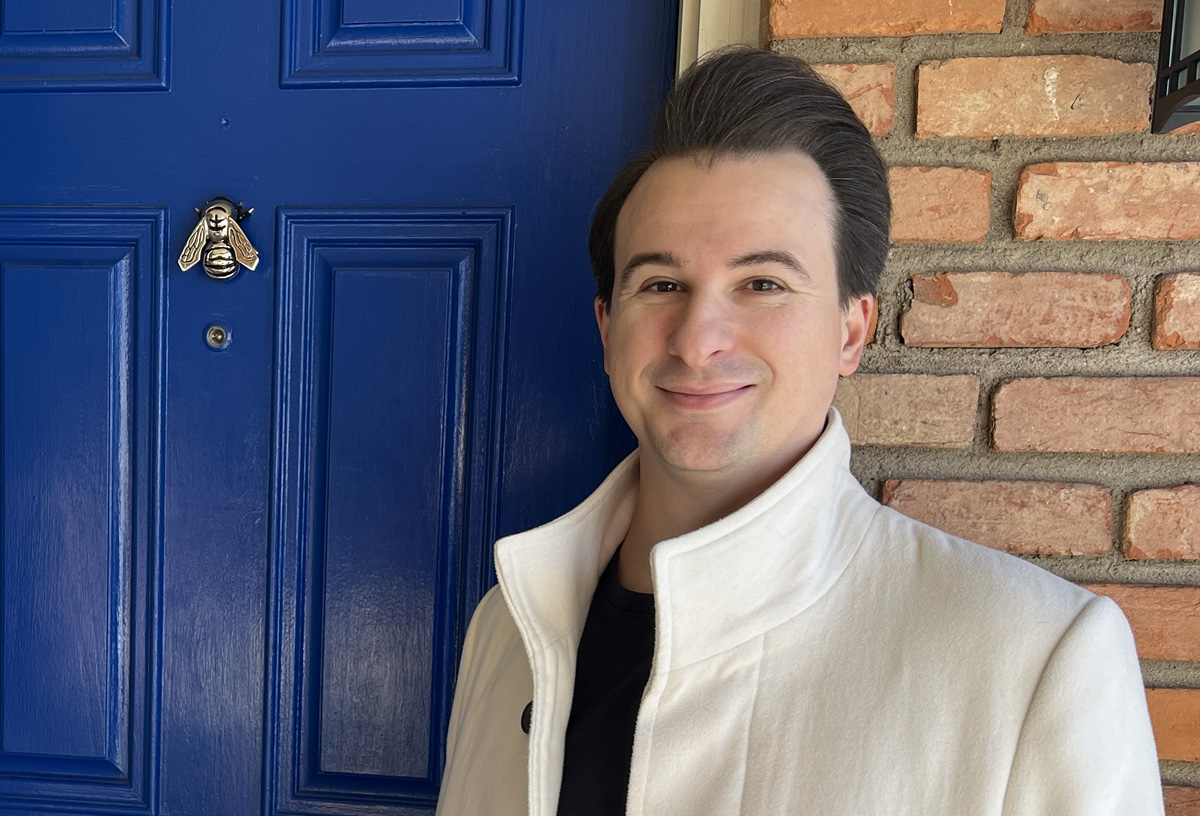 Josh Hendrickson standing next a blue door